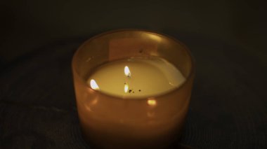 Sıcak mum alevinin yakın çekimi. Medya. Sıcak ve spa atmosferi yaratan bir mum. Sıcak ışık ve kaplıcada güzel kokulu Aroma mumu.