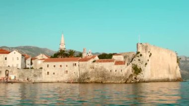 Mavi gökyüzü ile yaz manzarası ve kilise ile eski kasaba ve deniz dalgaları ile kule. Yaratıcı. Güzel doğa ve mimari