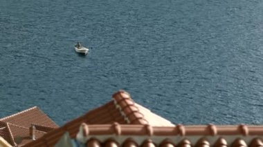 Binalar boyunca giden küçük bir teknesi olan yaz manzarası. Yaratıcı. Yaz tatili ve dalgalı deniz yüzeyi kavramı