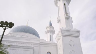 Mavi kubbeli ve parlak bulutlu arka planda kuleleri olan güzel beyaz cami. Sahne. Din ve inanç kavramı