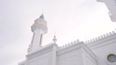 Yüksek yaldızlı kubbeleri olan büyük bir kilise. Mavi gökyüzü arka planında çeşitli dekorasyonları olan büyük beyaz bir kilise. Yüksek kaliteli FullHD görüntüler