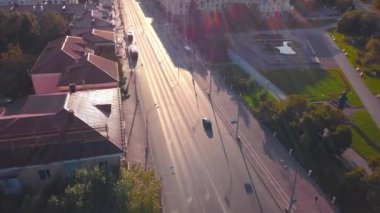 Güneşli bir günde arabalı güzel şehir yolu manzarası. Şarjör. Güzel evleri olan şehir otoyolu ve yazın sabah güneşi. Yolları ve yeşillikleri olan yaz kenti.