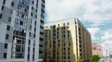 Yüksek binalar. Tock görüntüleri. Birçok aracın geçtiği yolun yanındaki büyük evler. Bulutsuz gökyüzünü görebilirsiniz. Yüksek kalite 4k görüntü