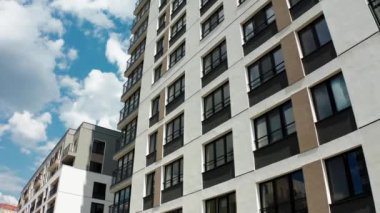 Konut binasının ön cephesinin panoramik görüntüsü. Stok görüntüleri. Güneşli bir günde modern apartmanın pencerelerinin görüntüsü. Modern komplekste konut binası pencereleri olan güzel bir cephe..