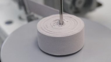Bir rulo kumaşı kesen makinenin yakın çekimi. Tekstil, üretim ve endüstriyel temalar için ideal.