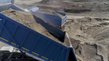Toprak dolu bir kamyon. Sahne. İnşaat alanında toprak olan çöp kamyonunun en üst görüntüsü. İnşaat alanı ya da içi toprak dolu çöp kamyonları olan taş ocağı..