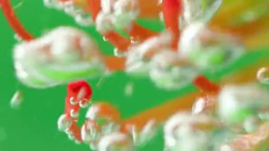 Su altında çiçek açan hava kabarcıklarıyla. Stok görüntüleri. Su altında, suyun içinde yüzen sarı ve turuncu çiçekleri yakından görebiliriz.