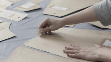 Bir moda stüdyosunda tebeşirle tebeşirle yakın plan çekimler. Desen oluşturma süreci.