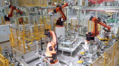 Rusya, Moskova - 7 Mayıs 2022: Robot ve işçilerle otomatikleştirilmiş fabrika. Sahne. Birçok robot makine modern fabrikada araba parçaları üretir. İşçilerin olduğu fabrikada modern robotik ekipman.