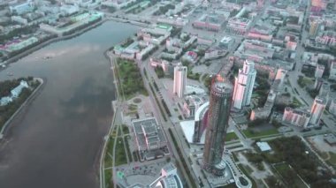 Helikopterden bir milyon kişinin yaşadığı büyük bir şehir. Tock görüntüsü. Büyük bina ve ofisler yıl ortasında uzun nehrin yanında yer alıyor. Yüksek kalite 4k görüntü