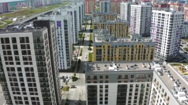 Parlak bir kuş bakışı görüntü. Büyük, yüksek binalar, farklı arabaların hareket ettiği otobanın yanında ve tepede güzel mavi bir gökyüzü. Yüksek kalite 4k görüntü