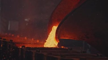 Çukur kalıplara sıvı metal döker. Stok görüntüleri. Çukurdan erimiş metal sıvısı dökülüyor. Metalurjik santralde sıvı metal akışı kalıplara dökülür.. 