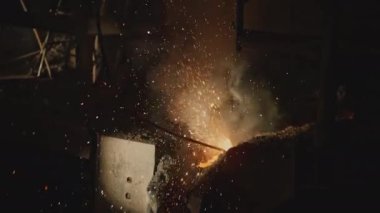 Fabrikada kızgın metal damlaları var. Stok görüntüleri. Fabrikada sıcak metal damlaları var. Metalurji fabrikasında erimiş metal patlaması.