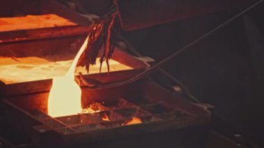Fabrikada sıcak metal akıntıları var. Stok görüntüleri. Güzel erimiş metal kalıplara dökülür. Metalurji fabrikasında metal akışı. 
