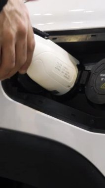 Elektrikli araba için şarj oluyor. Medya. Elektrikli arabaların şarj edildiği özel bir benzin istasyonunda beyaz bir araba. Yüksek kalite 4k görüntü