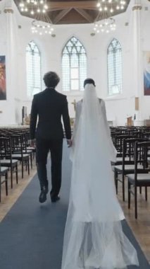 Sadece gelin ve damat için kilisede düğün töreni. Başla. Takım elbiseli bir adam ve beyaz elbiseli bir kadın kilisenin boş sıralarında mihraba doğru yürüyorlar.