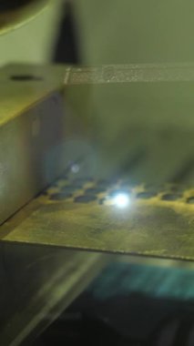 Fabrikada yanan lazer makinesine yakın çekim. Medya. Metal nesnelerin üzerindeki noktaları yakan lazer. Fabrikada lazer yakma makinesi..