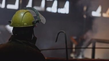 Metalurji fabrikasında ekipman işçisi. Stok görüntüleri. Fabrikada sıcak metali olan çok çalışkan bir işçiydi. Metalurji fabrikasında yüksek sıcaklık üniforması giyen bir işçi.. 