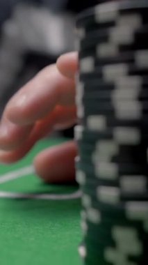 Kumar oynayın. Başla. Poker masasına çip koyan adama yakın çekim. Adam pokerde çiplerle bahis oynuyor..