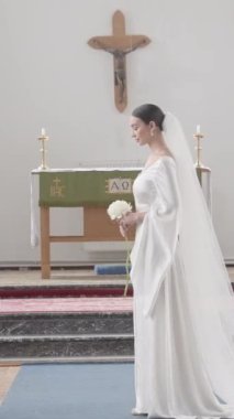 Kilisedeki evlilik yemini. Eylem. Yeni evliler haçlarla süslenmiş büyük bir tapınakta duruyor ve birbirlerine yemin ediyorlar. Yüksek kalite 4k görüntü