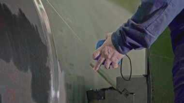 Fabrikada dönen beton varil. Borsa klipsi. İşçi fabrikada dönen varilleri ölçer. İşçi, dönme mekanizmasını beton bobbin ile kontrol ediyor. 