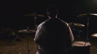 Davul setinde oturan adam. Şarjör. Davulda oturan adamın dikiz görüntüsü. Muzlu adam gece katılmaya hazırlanıyor.. 