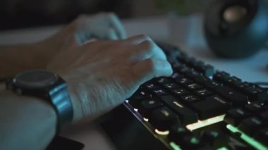 Parlak klavyede yazan erkek ellerinin yakın çekimi. Şarjör. Adam profesyonel arka planda klavye kullanıyor. Bilgisayarda çalışmak ya da çalmak için arka planda klavye kullan. 