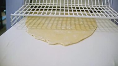 Endüstriyel makineye hamur döküyorum. Şarjör. Endüstriyel şirkette hamur makinesi. Çiğ hamur makineli yemek ekipmanları. 