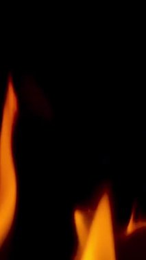 Gelişen bir yangın. Şarjör. Sarı - turuncu alev siyah arkaplanda dalgalanıyor