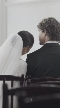 Modern kilisedeki düğün töreninde gelin ve damat. Başla. Kadın ve erkek boş koltuklarda yan yana oturuyor.