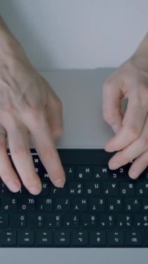 Eller klavyeye basıyor. Başla. Dizüstü bilgisayarın klavyesinde yazı yazan ellerin üst görüntüsü. Kişi minimalist tarzda yeni dizüstü bilgisayarda yazıyor.