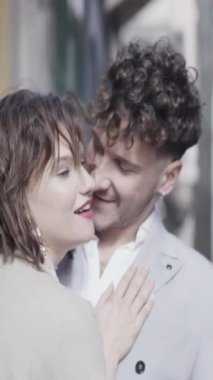 Güneşli bir düğün gününde sokakta kucaklaşan evli bir çift. Başla. Bulanık dar bir sokakta sevecen gelin ve damat