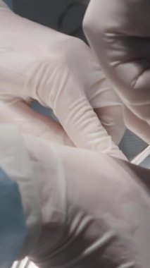 Cerrahların elleri ameliyat sırasında yakınlaşır. Başla. Cerrahların elleri ve asistanları hastayı ameliyat eder. Hasarlı veya enfekte olmuş organ ameliyatı.