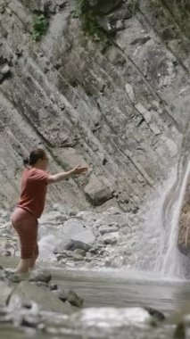 Bir anne ve oğlu İsveç 'in kuzeyinde bir dağ deresinde yüzüyorlar. Yaratıcı. Yaz tatili kavramı, kayalar arasında soğuk su akıntısı