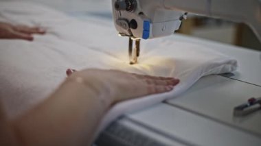 Fabrikada beyaz yastık kılıfı diken terziye yakın durun. Medya. Dikişte kadın eli.