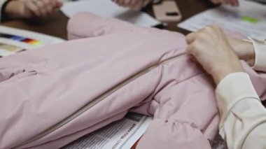Bir kadın tasarımcı çocuk kıyafetleri üzerinde çalışıyor. Medya. Yeni tulumun kalitesini ölçen kadınlara yakın çekim