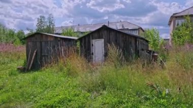 Arkaplanda terk edilmiş evler var. Şarjör. Köydeki terk edilmiş binalar yüksek binaların arka planında. Terk edilmiş fakir mahallelerin aksine.