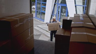 Kargo işçileri karton kutularla kamyonu yüklüyorlar. Medya. Paketleri minibüse koymak, profesyonel kurye konsepti satın alınan eşyaları etkili bir şekilde teslim etmek.