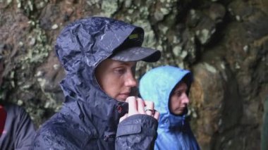 Mağaraya turist grubu gezisi. Şarjör. Bir grup turist mağaranın girişinde duruyor ve endişeyle brifingi dinliyor. Mağara eğitmeniyle grup yürüyüşü.. 