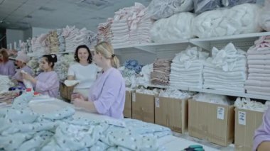 İş yerindeki tekstil işçileri giysilerin bitmiş ürünlerini paketliyor. Medya. Ulaşım için kumaş ambalajı