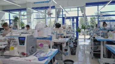 Üretim işi, kadınlar dikiş makineleri için çalışıyor. Medya. Çalışma sırasında giysi fabrikası 