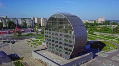 Yenilikçi Kültür Merkezi Binası. Borsa klipsi. Yuvarlak şekilli modern cam bina. Yakınlardaki şehrin arka planında modern yuvarlak şekilli mimarisi olan kültür binası. 