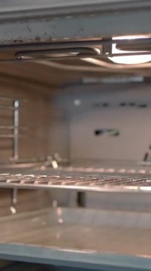 Yemek pişirme kavramı. Başla. Isıtmalı bir soba, tavayla tepsinin içine itiliyor. Yüksek kalite 4k görüntü