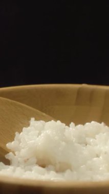 Yakın çekim sıcak pirinç ve tahta kaşık ile ahşap kase. İştah açıcı pirinç restoranda servis hazırdır.