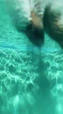 Adam havuza atlıyor. Sahne. Sualtı video çekimi. Yüzücü havuza atlıyor..