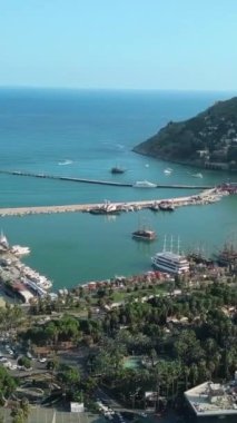 Deniz kıyısında küçük bir güney kasabasının havadan görünüşü. Şarjör. Deniz armudu ve turkuaz su, yeşil şehir ve tepeler