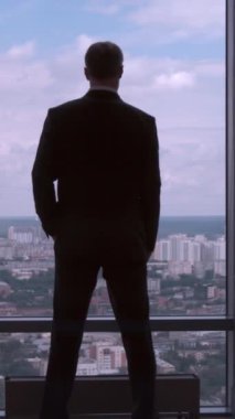 Bel, Ceo üzerinde tam uzunlukta arkadan görünüm takım ayakta eller ofiste başarılı iş adamı. Bir şehir görünümü penceresindeki 4 k önünde arkasından işadamı