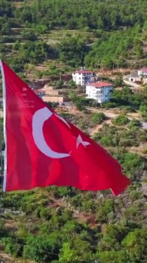 Türkiye 'nin ulusal tehlike bayrağının havadan görünüşü. Şarjör. Yaz yeşili dağ ve binaları olan bitki örtüsü