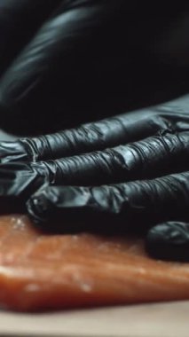 Suşi şefi eldiven Close-Up suşi barda taze somon dilimleri. Somon fileto Dilimleme.