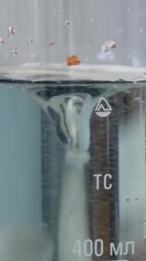 Renk karıştırma sonra sıvı değiştirir. Sıvı özel bir cihaz tarafından karışık renkli şişeye Close-Up.